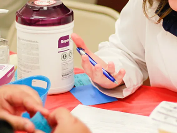A pharmacist speaking with a patient during a health fair. 