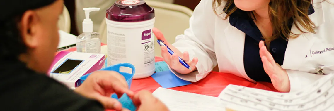 A pharmacist speaking with a patient during a health fair. 