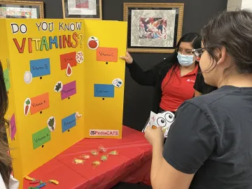 Students gathered around a poster presentation.
